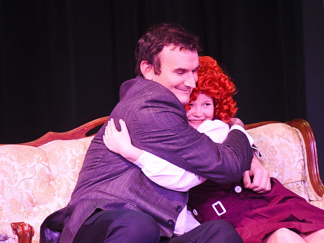 Oliver Warbucks (played by Reid Knuth) and Annie (Helena Roessner) hug during last week’s rehearsal for the Jay County Civic Theatre production of the musical “Annie.” The show will open with a performance at 7 p.m. Thursday. Additional shows are scheduled for Dec. 5, 6, 12, 13 and 14. Tickets are available at bit.ly/JCCTAnnie, by calling (260) 726-4809 or at Arts Place, 131 E. Walnut St., Portland. (The Commercial Review)