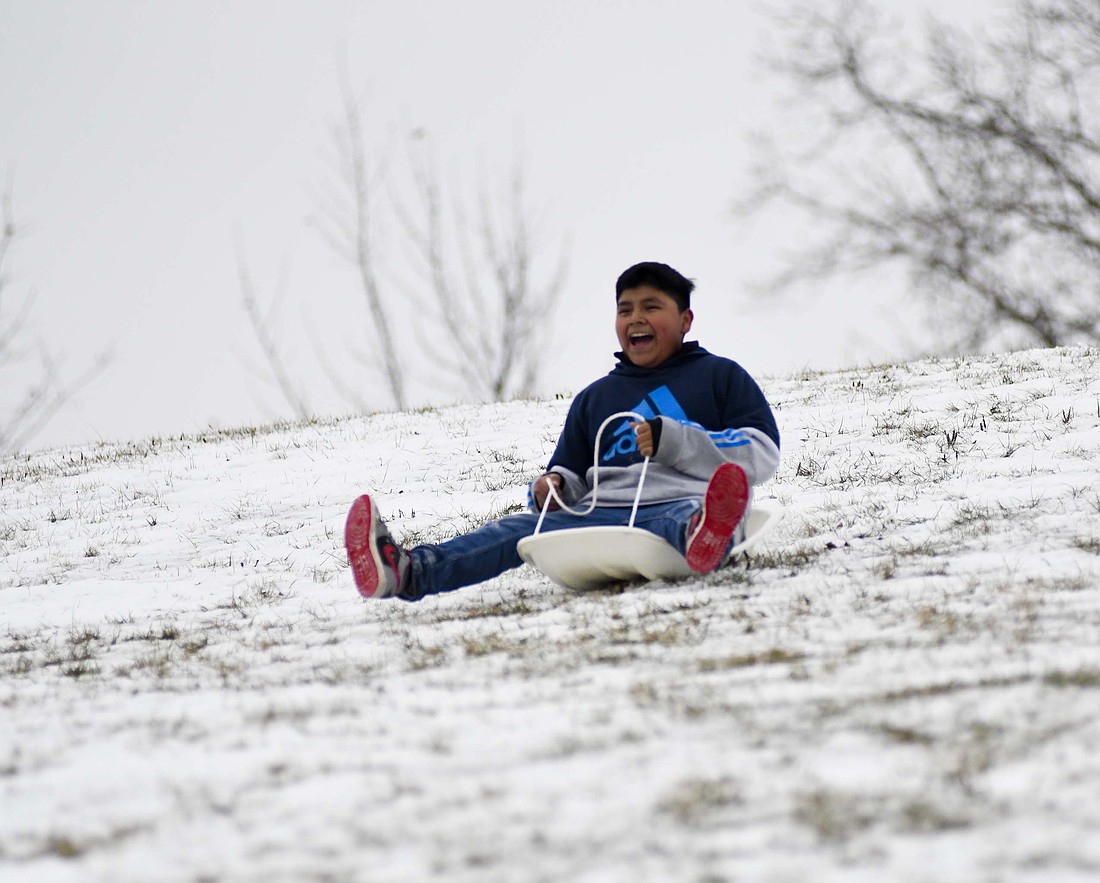 Wolfe Mendez, 12, shouts while sledding down the hill at Hudson Family Park on Sunday afternoon in Portland. (The Commercial Review/Andrew Balko)