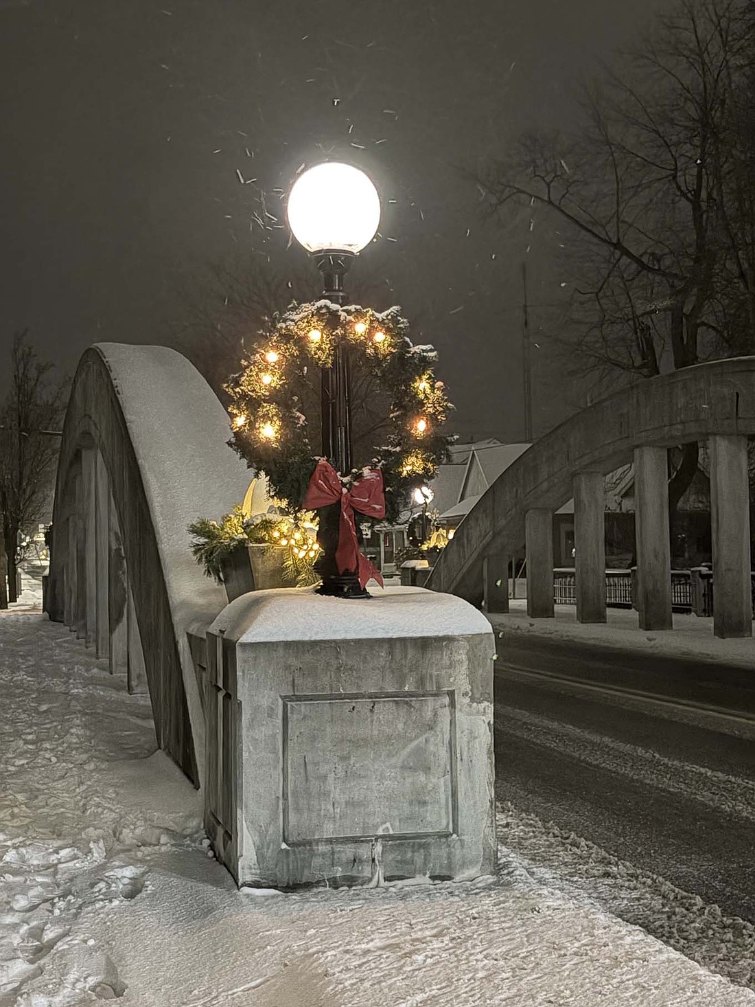 Snow falls gently Saturday evening at the Meridian Street arch bridge over the Salamonie River in Portland. (The Commercial Review/Ethan Oskroba)