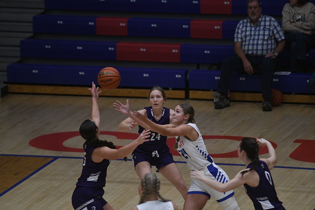 Jay County High School girls basketball’s Kendall Schemenaur reaches for a loose ball as Fort Recovery’s Emma Schmitz looks on. Schemenaur’s Patriots trailed at the half but came away with a 55-43 win on Saturday. (The Commercial Review/Ray Cooney)