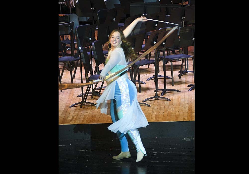 Audrey Evans of the Jay County High School color guard spins a ribbon during the group’s performance to the Sia song “Snowman” during Sunday’s Christmas concert. The event included performances by the jazz and concert bands, the color guard and the show choirs. It concluded with a combined performance from the band and choir of “A Festive Christmas Celebration.” (The Commercial Review/Ray Cooney)
