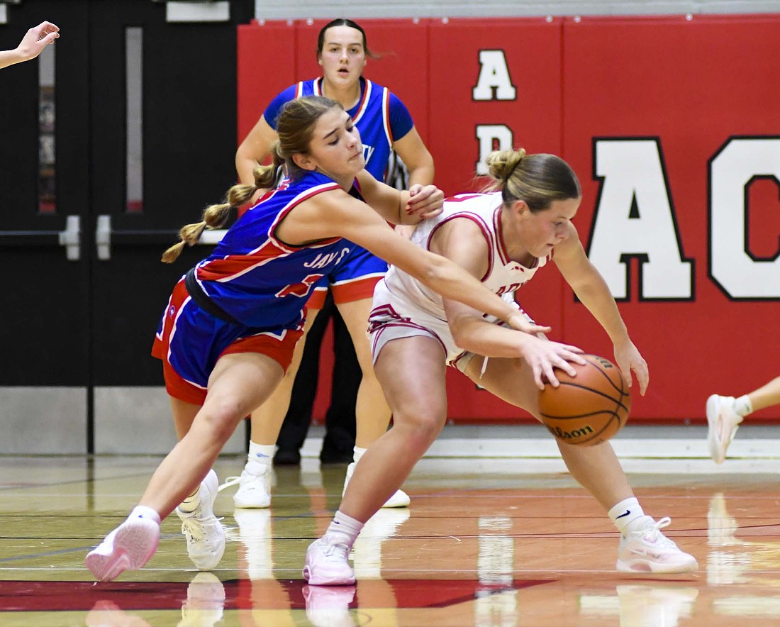 Jay County High School’s Claudia Dirksen reaches to try and steal the ball away from Ava Stafford of Adams Central during the 50-45 victory on Friday. The Patriots struggled with turnovers through the first three quarters but a late run in the third quarter and some strong defense fueled a comeback in the Allen County Athletic Conference opener for JCHS. (The Commercial Review/Andrew Balko)