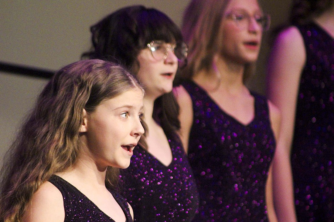Members of the junior high choir, including Finley Thompson (foreground left) perform Sunday during the Fort Recovery Local Schools Christmas Choir Concert. The junior high choir’s selections included “Hot Chocolate” and “Believe” from “The Polar Express.” (The Commercial Review/Bailey Cline)