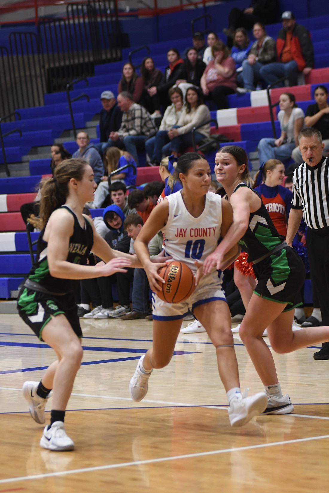 Raylah Newton of the Jay County High School girls basketball team splits a pair of New Castle Trojans during the Patriots' 75-58 win over New Castle on Thursday. Newton posted nine points while sisters Hallie (31 points) and Karsyn Schwieterman (26 points) sparked the Patriot attack. (The Commercial Review/Ethan Oskroba)