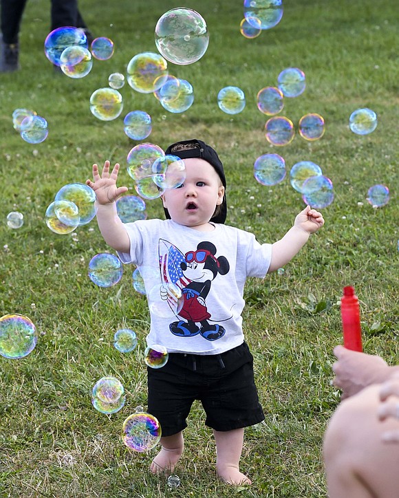 Jay County football fans had some fun Aug. 22 with a pre-game tailgate party that included music from John Beatrice Band, food, games and other activities. Pictured, 1-year-old Frank Hess plays in the midst of a bunch of bubbles blown by his aunt Gabby Williams. (The Commercial Review/Andrew Balko)