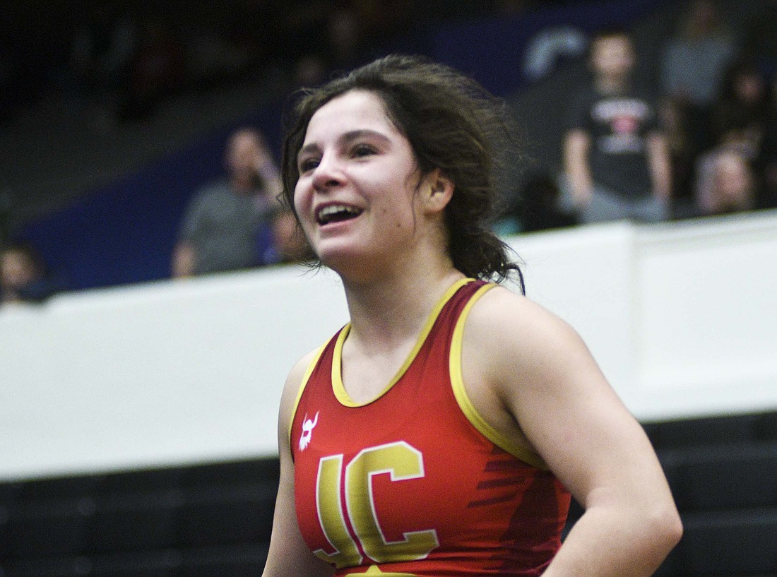 Jay County High School senior Katie Rowles grins as she runs toward her coaches, including her dad Pat, after upsetting second-ranked Claire May in the semifinal round of the 100-pound bracket during Saturday’s regional tournament at Muncie Central. Rowles had already earned a state berth and went on to finish as the regional runner-up. (The Commercial Review/Ray Cooney)