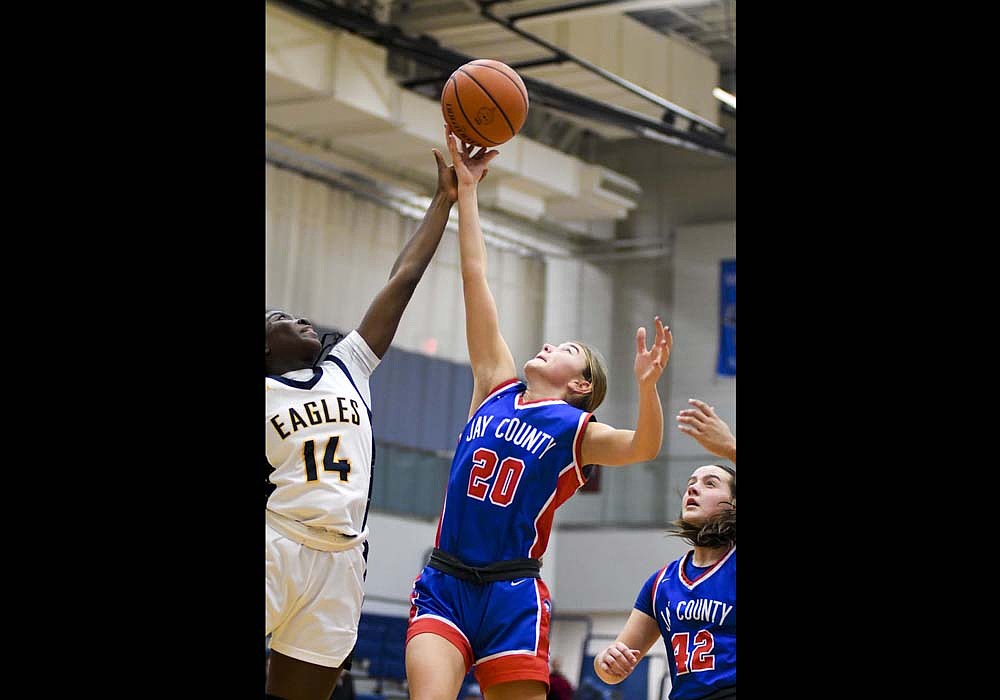 Claudia Dirksen of the Jay County High School girls basketball team extends her arm up to try and grab a rebound away from Delta’s Elizabeth Bamidele during Thursday’s 55-51 victory. While the Schwieterman sisters combined for 33 points to fuel the Patriots, JCHS needed a full-team performance to pick off the sectional foe. (The Commercial Review/Andrew Balko)