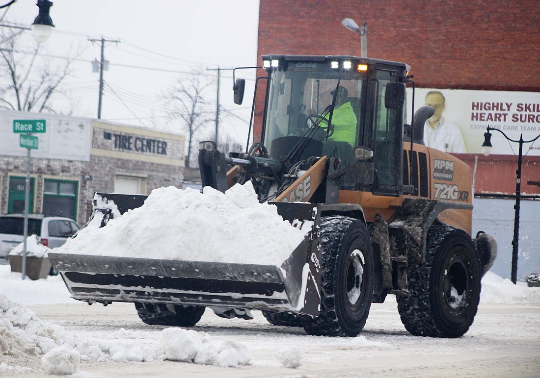 A Portland Street Department employee removes snow from the median Tuesday at the intersection of Meridian and Race streets in Portland. City crews spread 6.5 tons of salt on Monday. (The Commercial Review/Bailey Call)